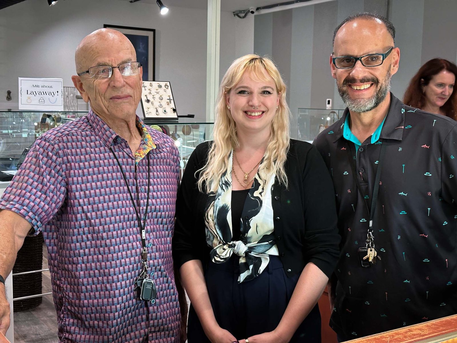 Three members of the Abby's Pawn & Coin team behind the jewelry counter
