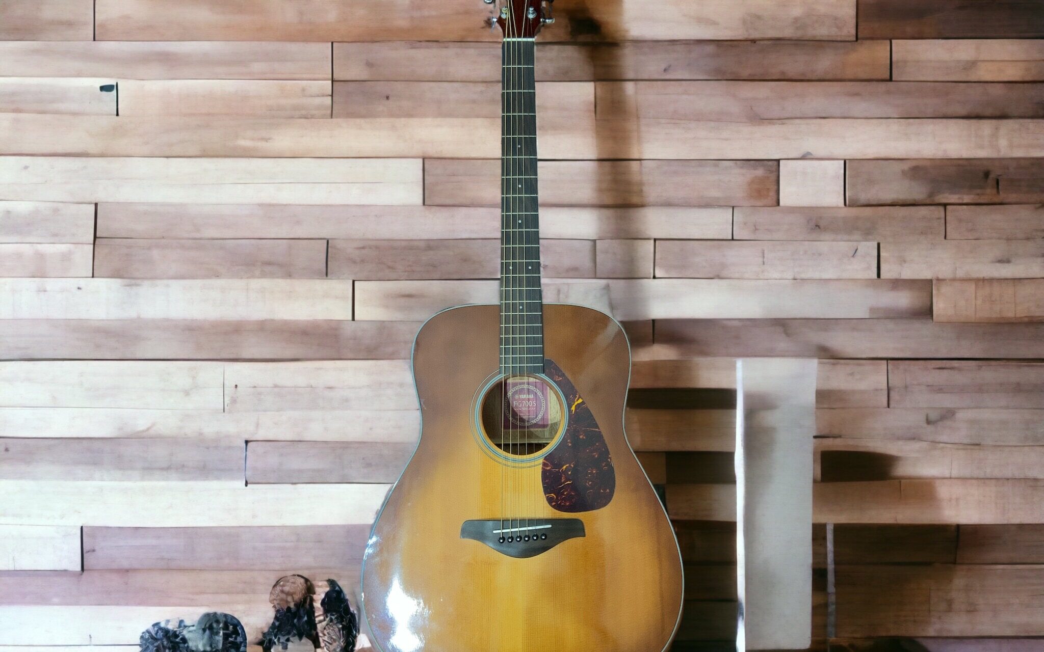 A guitar sitting against a wall.